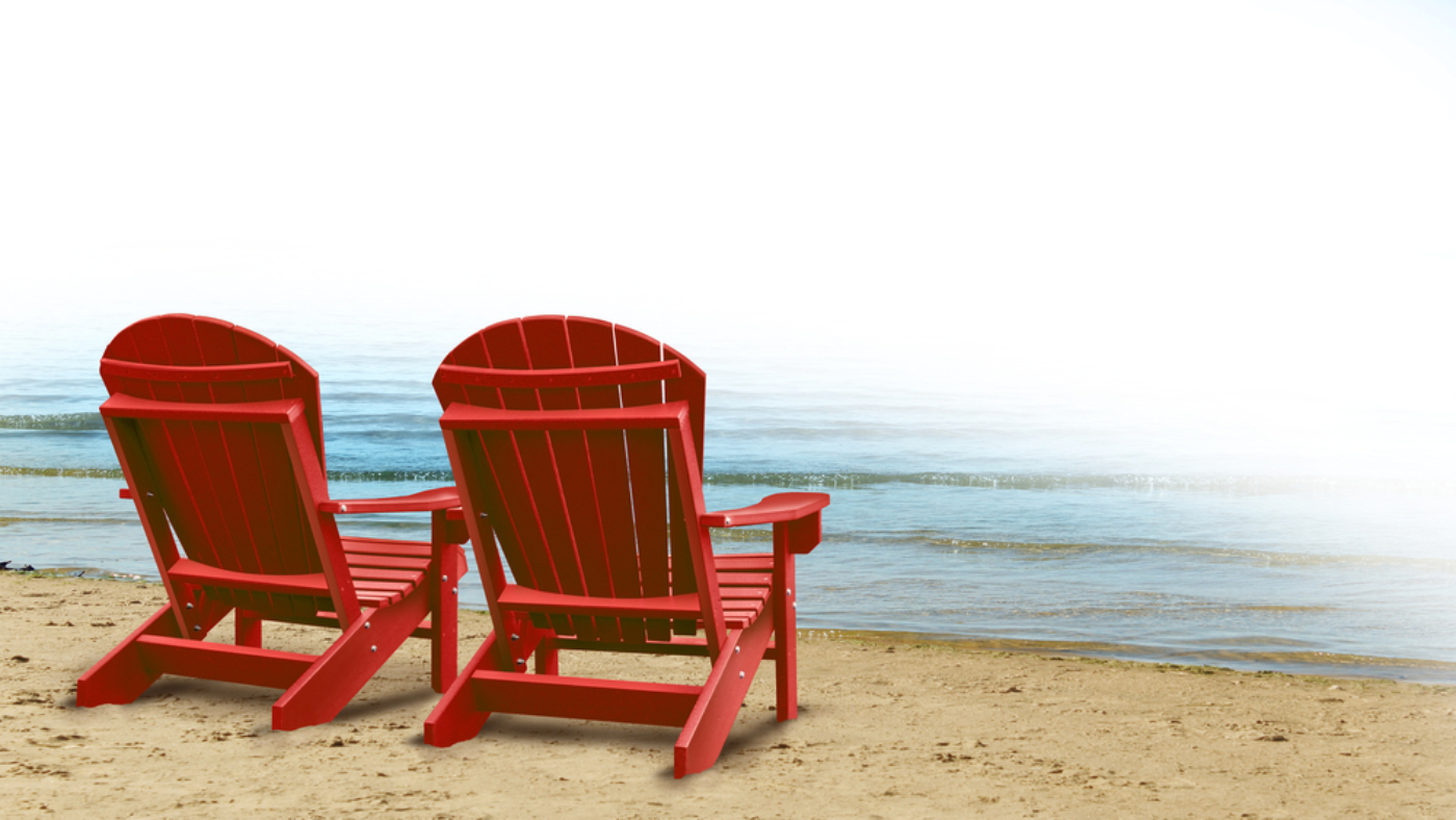 Two Adirondack chairs by the sea
